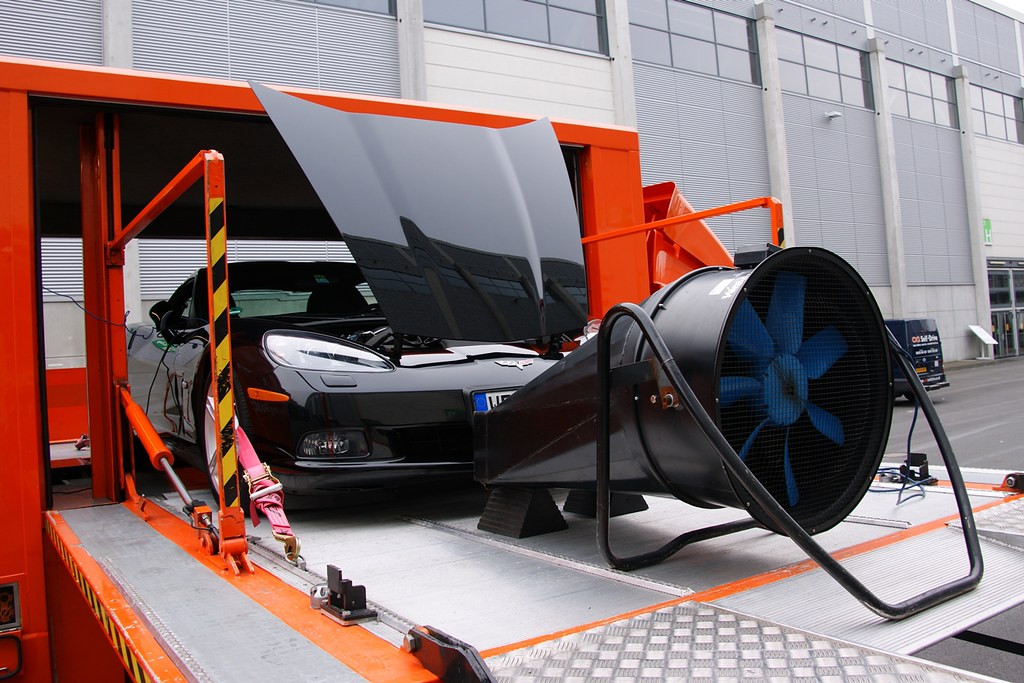 Car secured inside a mobile rolling road with a large cooling fan