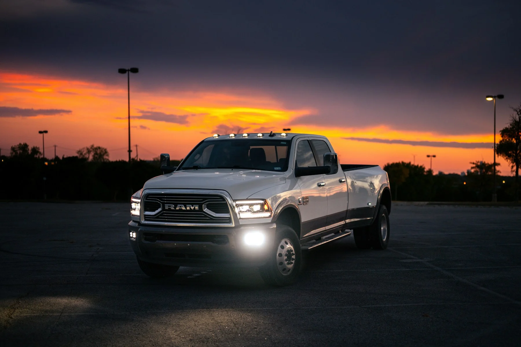 Ram diesel dually pickup on a rural road at dusk