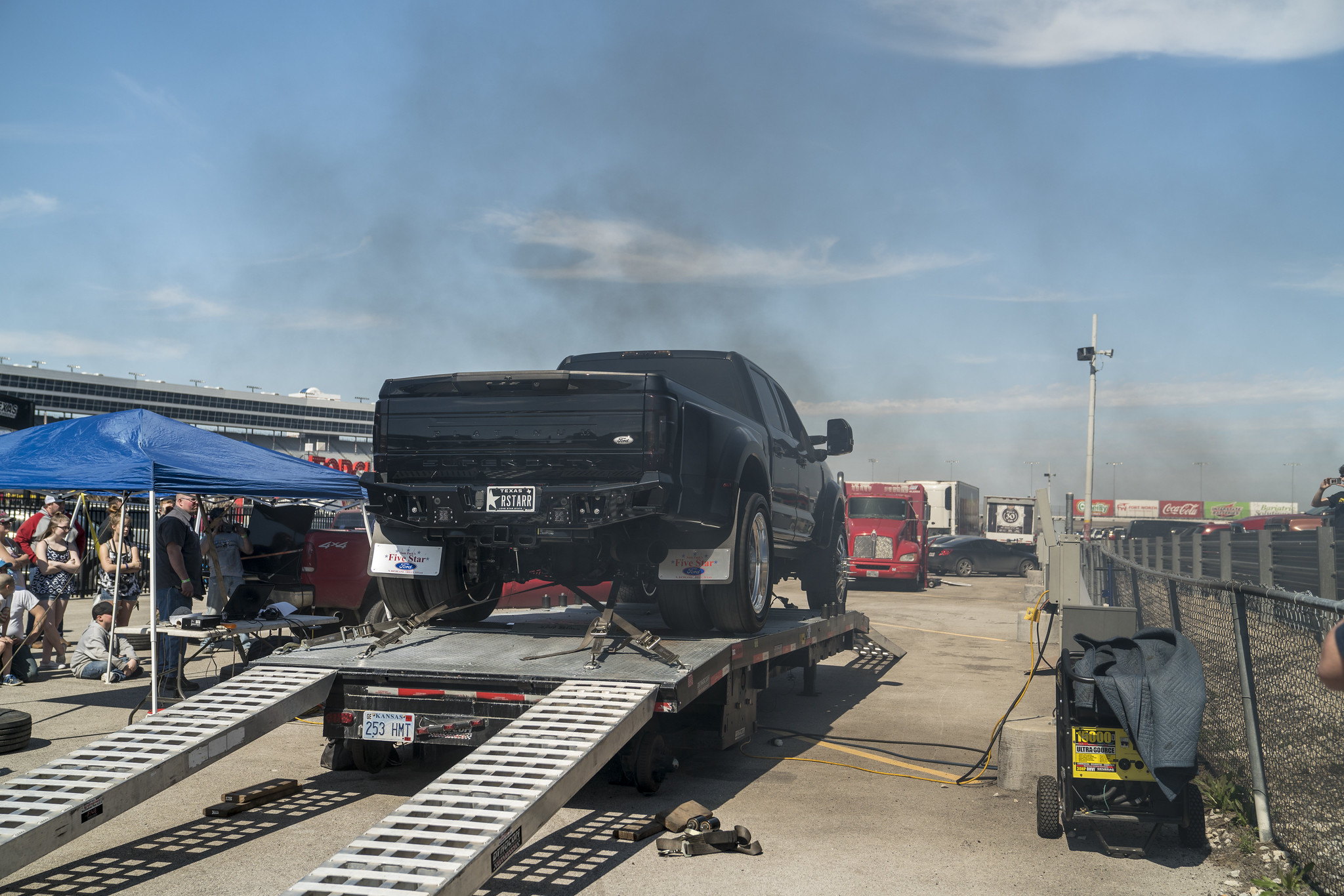 Black Ford dually pickup on a mobile dynamometer with spectators at an outdoor truck event